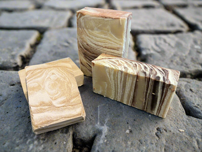 Swirled cream soap bars on gray stone surface, three pieces