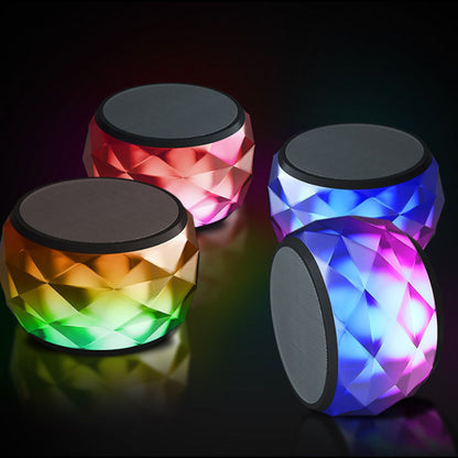 Four mini LED Bluetooth speakers with red, blue, and green faceted lighting and black tops