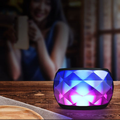 Mini LED Bluetooth speaker with blue and pink faceted lighting and black top grille