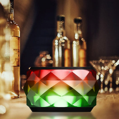 Mini LED Bluetooth speaker with red and green faceted lighting and black top grille