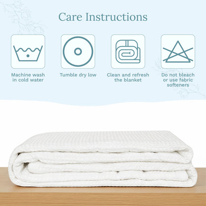 Waffle weave blanket, folded white stack with waffle texture on a wood surface