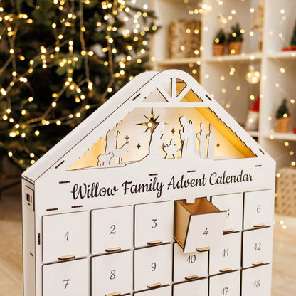 White advent calendar with open drawer at number 4, roof nativity window lit