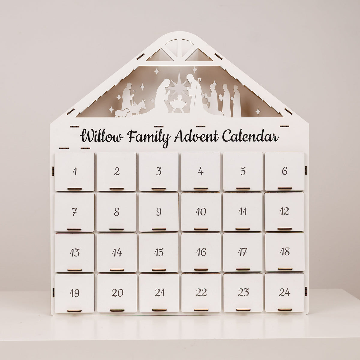 White advent calendar with 24 numbered drawers and nativity scene on front
