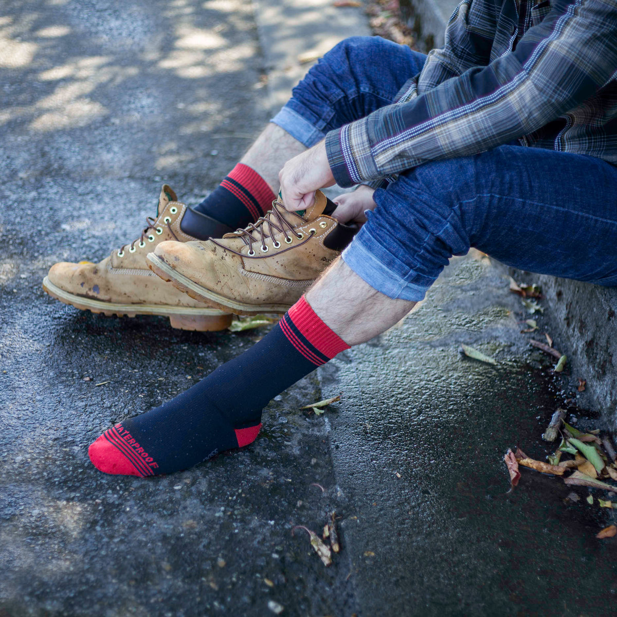 Socks on feet with dark blue body, red striped cuff, and red heel/toe