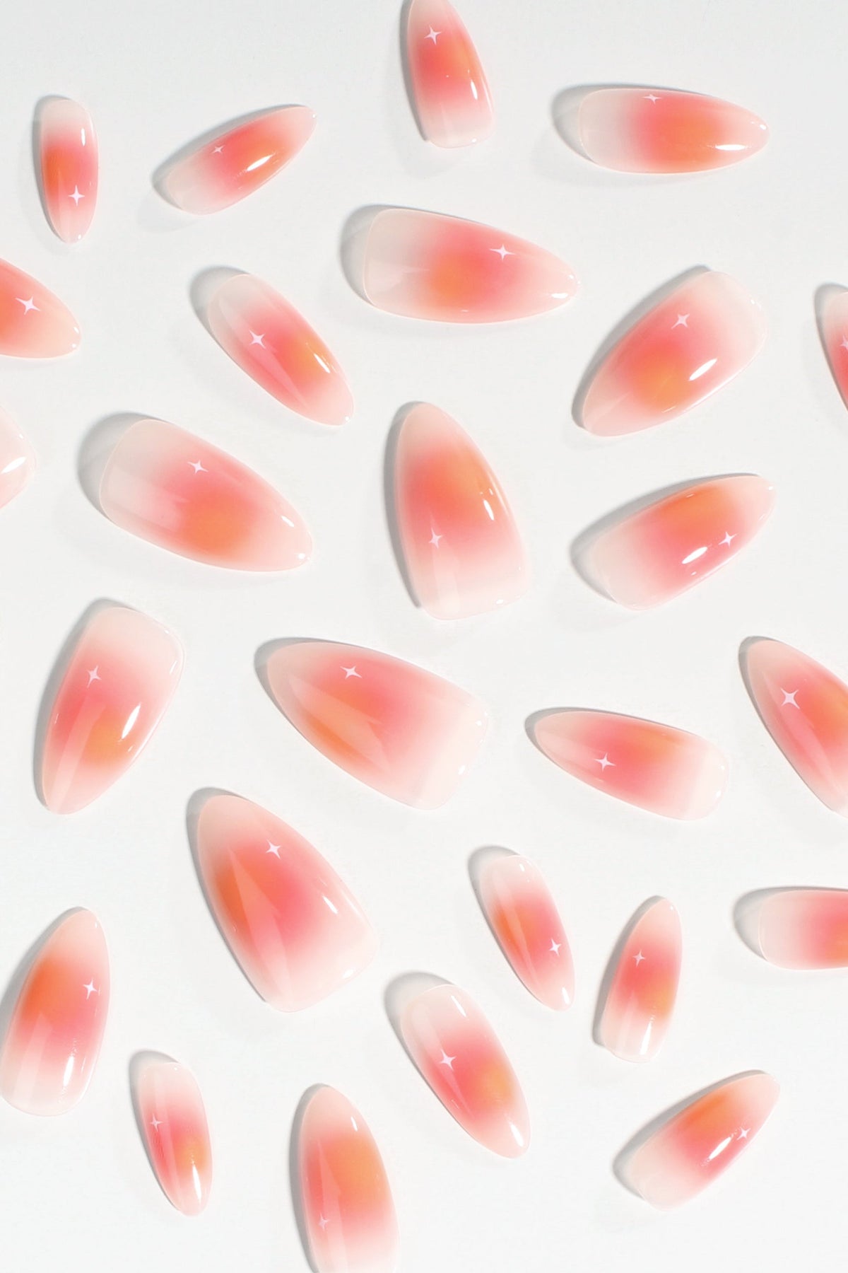 Assorted short oval press-on nails with coral-to-peach ombre and glossy shine