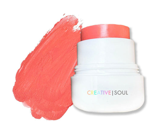 Coral-pink blush jar with red cap beside paint-like smear