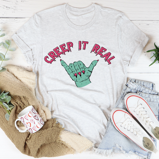 Light grey T-shirt with green hand graphic and red Creep It Real lettering