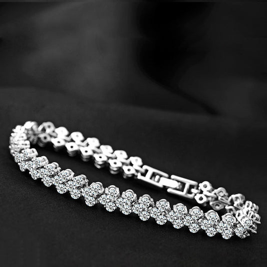 Silver tennis bracelet with round clear CZ stones and hinged clasp.