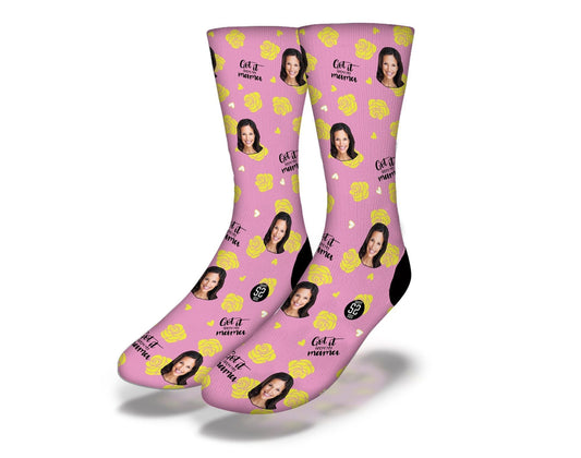 Pink crew socks featuring repeating portraits, hearts, and logo-style text.