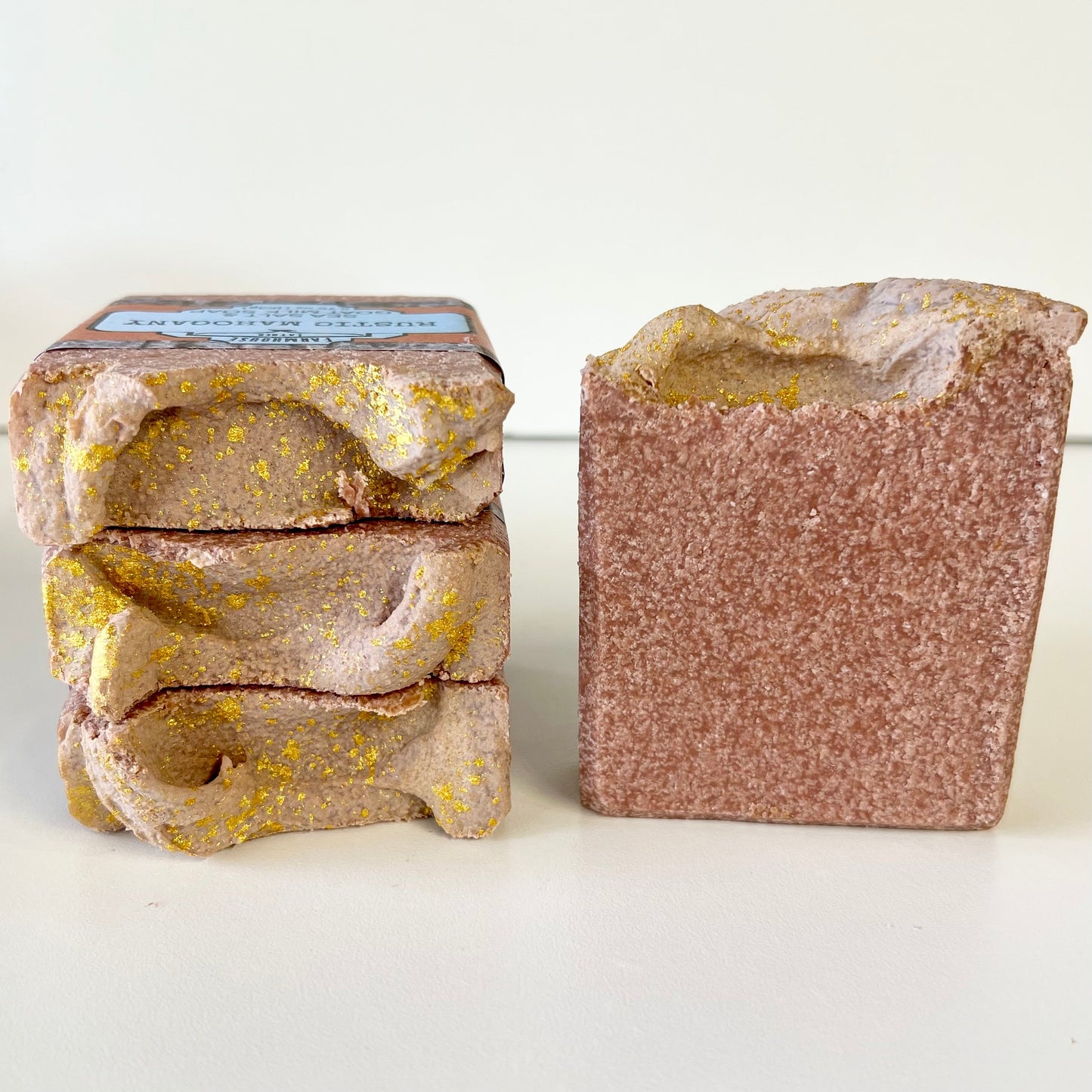 Sea salt soap bars: stacked bars and one unwrapped bar in rustic mahogany with speckling