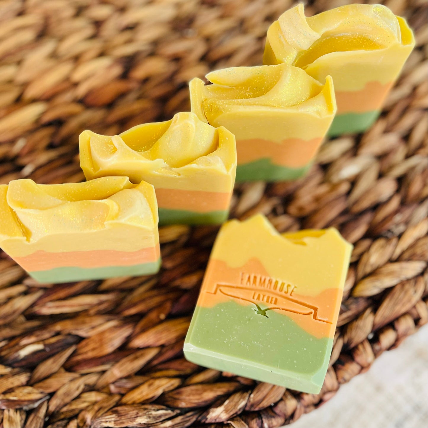 Soap bar and stacked pieces in yellow, orange, and green on woven tray