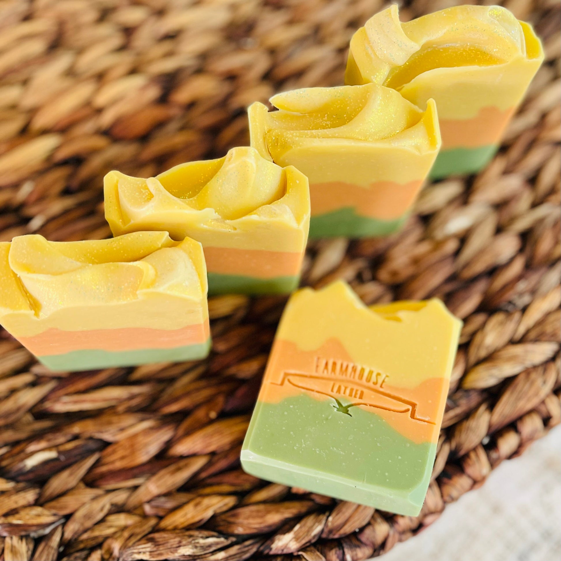 Soap bar and stacked pieces in yellow, orange, and green on woven tray