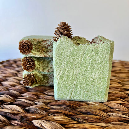 Green sea salt soap bar with pinecone topper on woven straw mat