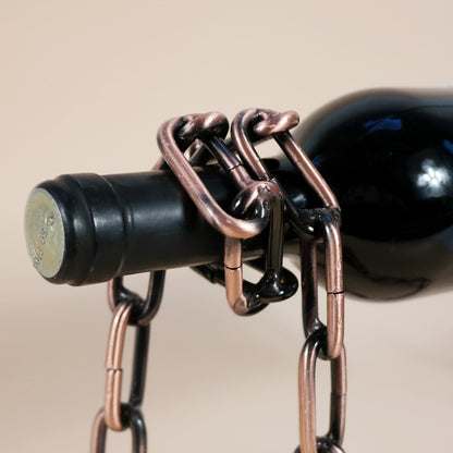 Wine bottle holder close-up of clasp and copper-toned chain on dark bottle