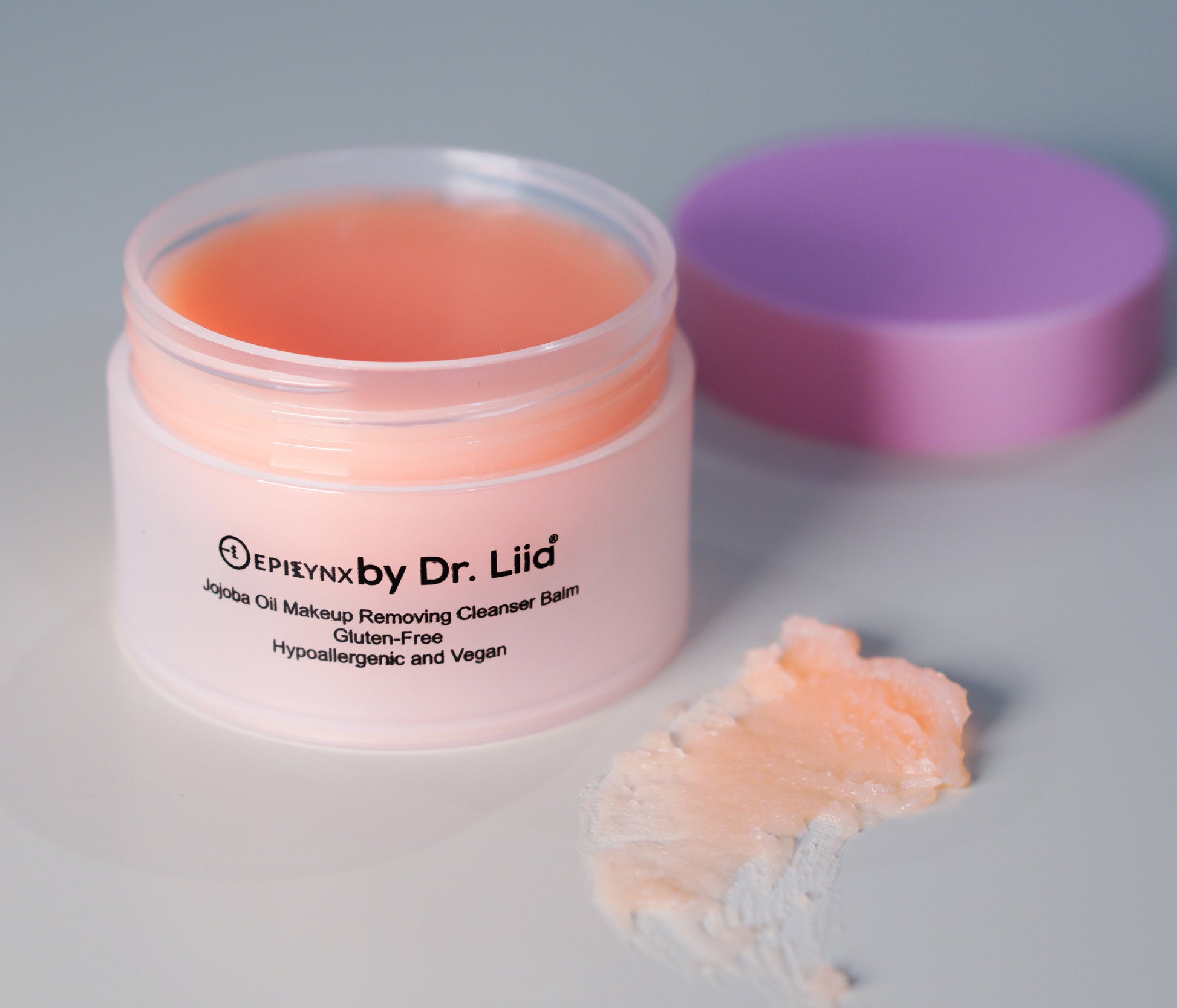 Peach makeup remover cleansing balm jar with open lid and balm scoop