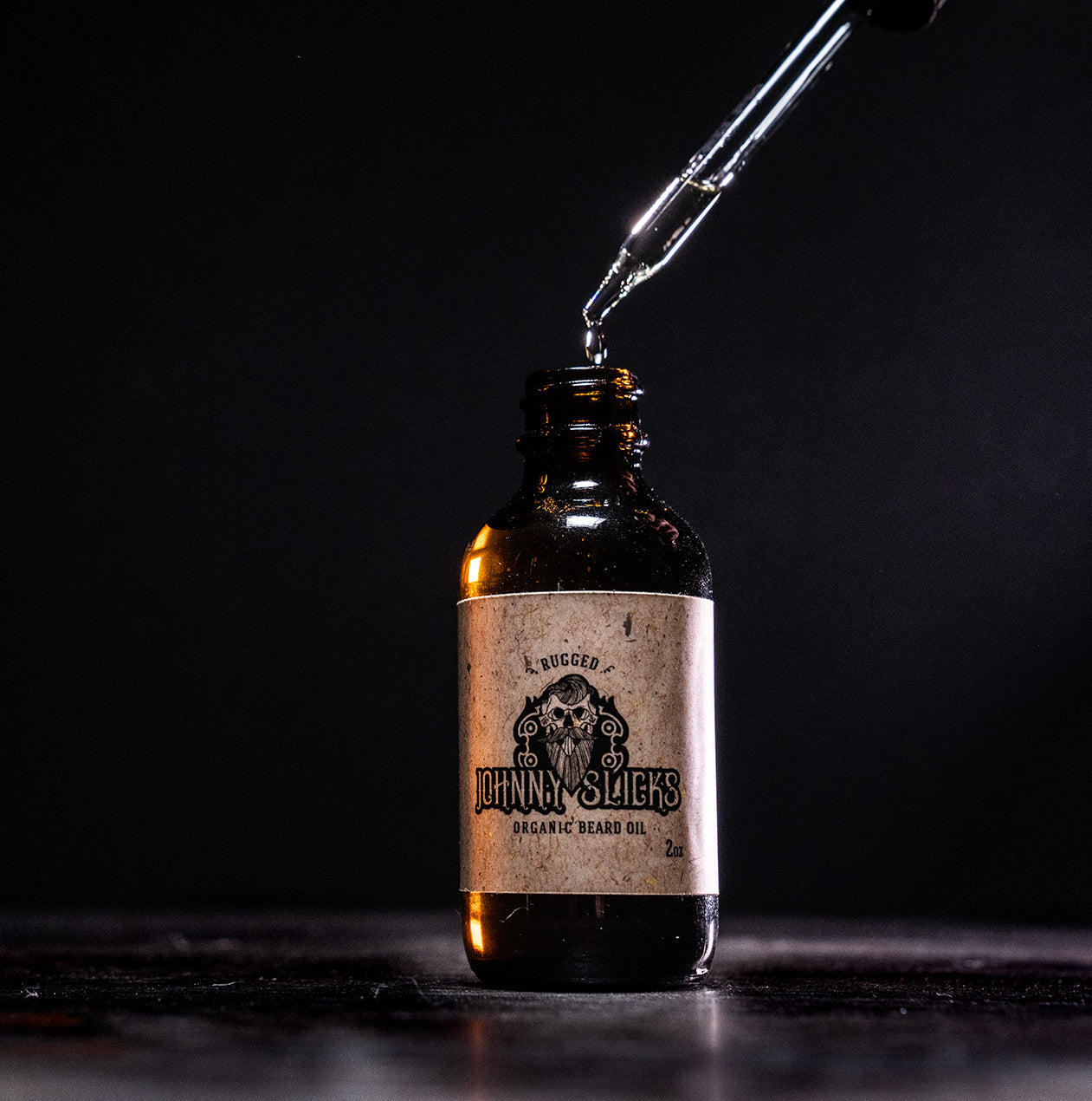 Organic beard oil bottle with black dropper; amber bottle with oil stream pouring.