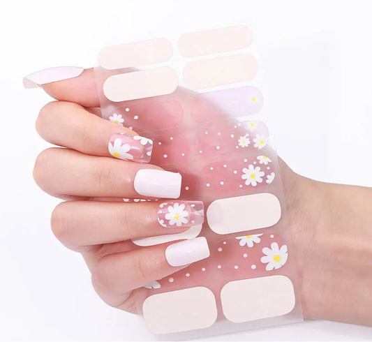 Gel nails with white square tips, daisies and tiny dot accents on several nails