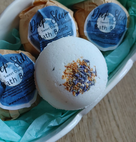 White bath bomb with blue flower topping, in teal wrapped box