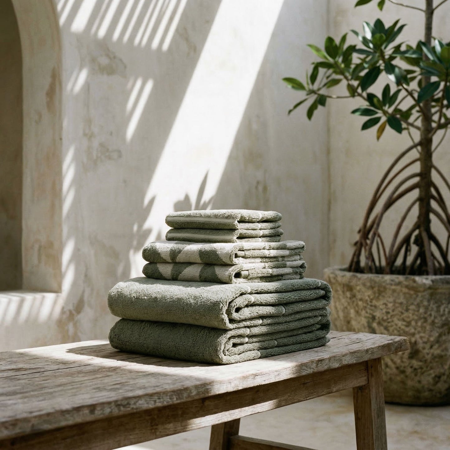 Cotton beach towels stacked, gray-green and white geometric triangle pattern