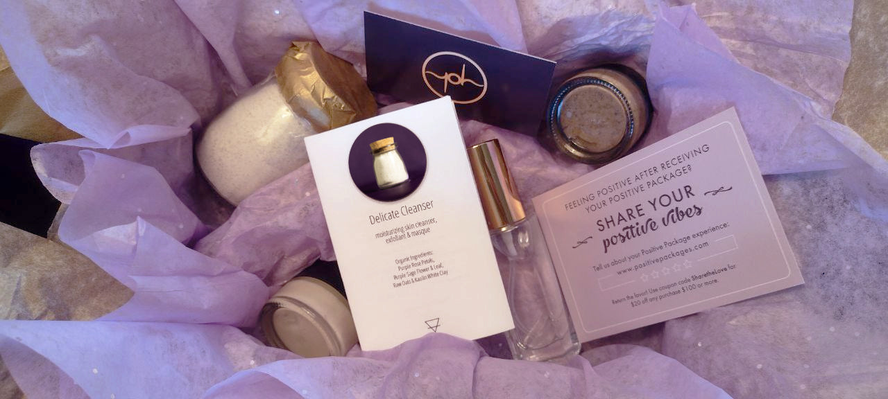 Glowing skincare package with multiple small bottles, jars, and printed cards