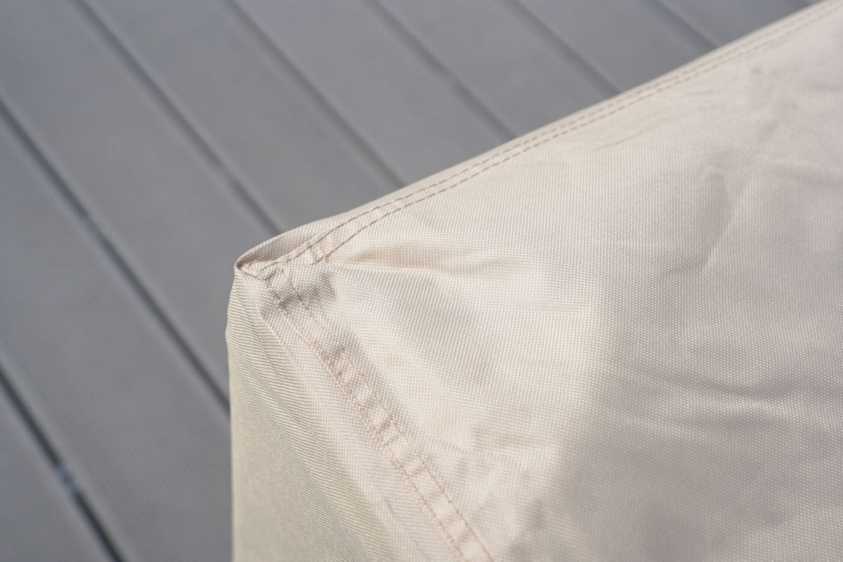 Corner of light beige/cream patio sofa cover with stitched seam detail.
