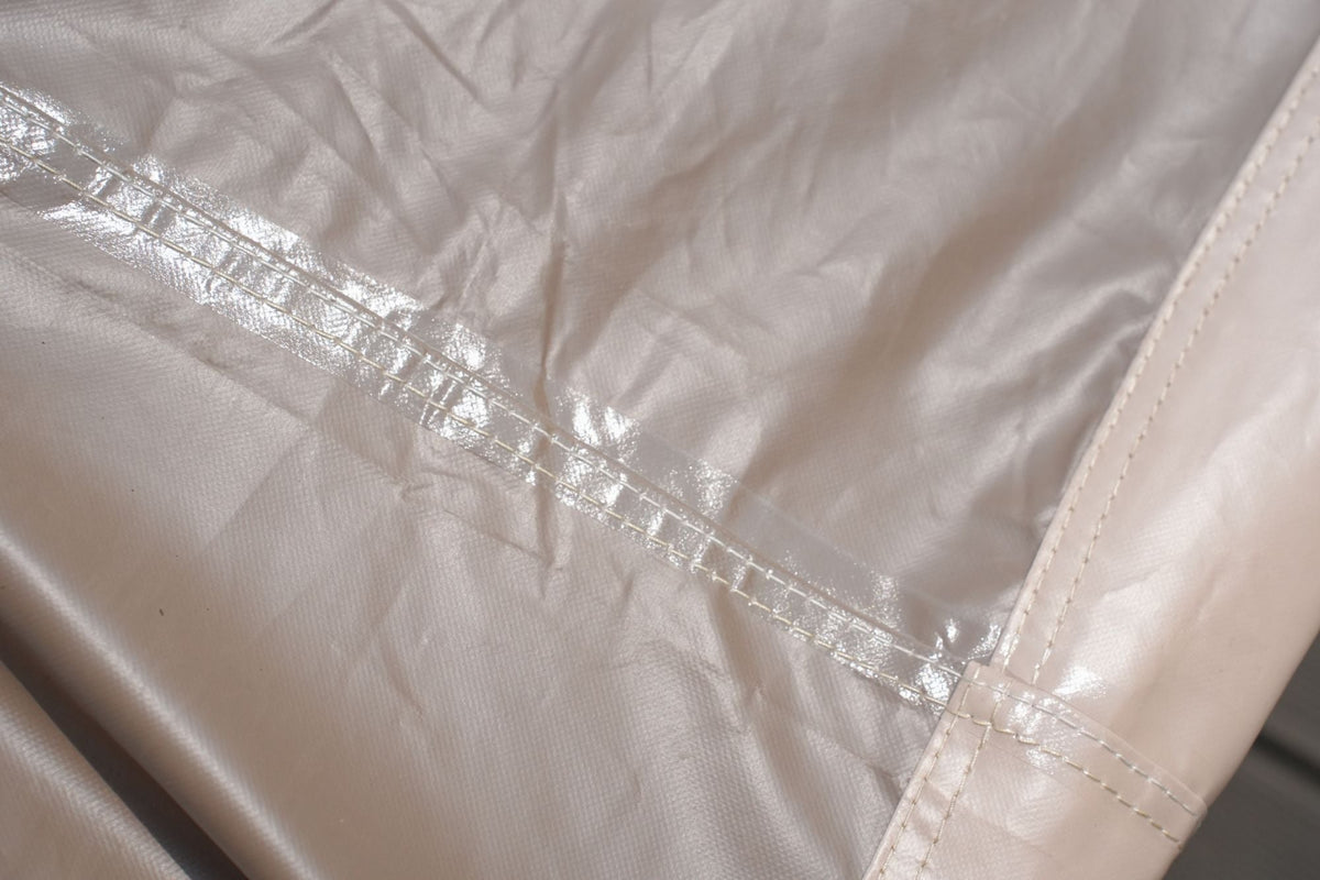 Outdoor furniture cover seam close-up, tan stitched reinforcement on panels