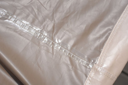 Outdoor furniture cover seam close-up, tan stitched reinforcement on panels