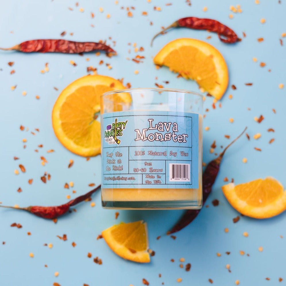 Dirty Dangles Lava Monster candle in clear glass jar with blue label and orange wax