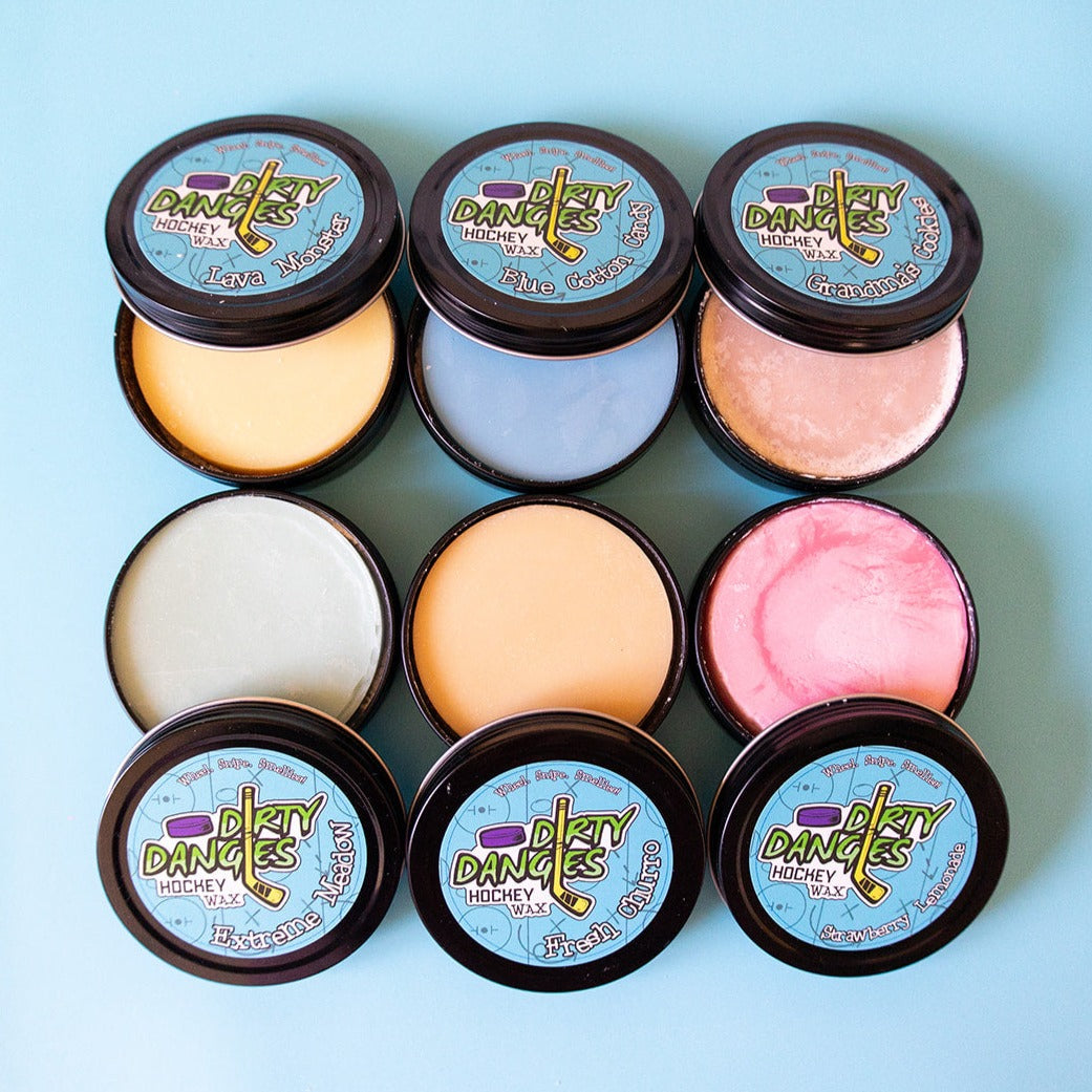 Set of round hockey wax tins with pastel yellow, white, peach, pink, and blue wax lids