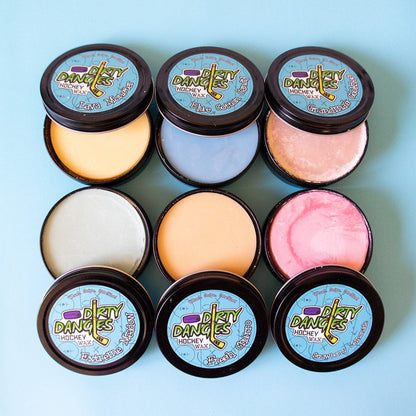 Set of round hockey wax tins with pastel yellow, white, peach, pink, and blue wax lids