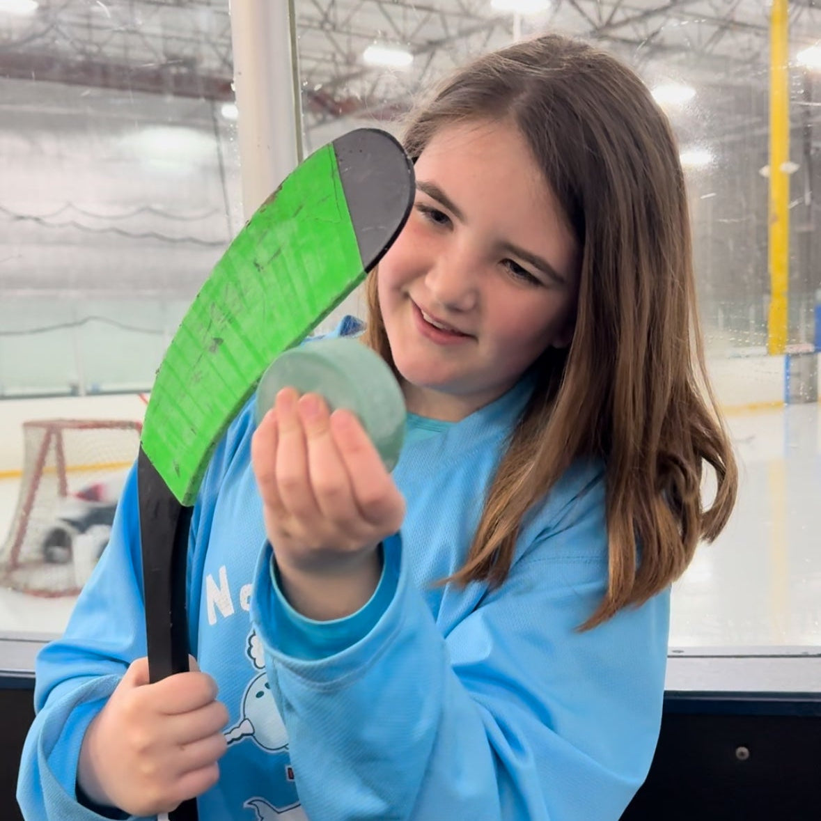 Paddle-shaped hockey stick wax block in green and gray.