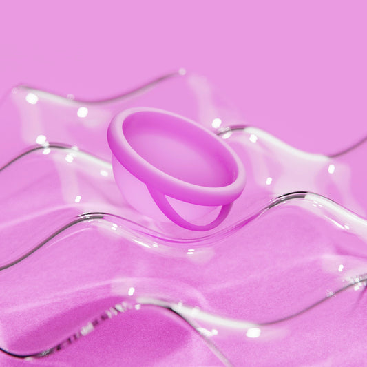 Pink menstrual disc close-up with soft rim and inner cavity visible