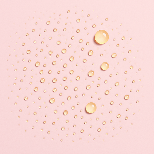Fine droplets of hydration mist with glossy golden beads on a surface