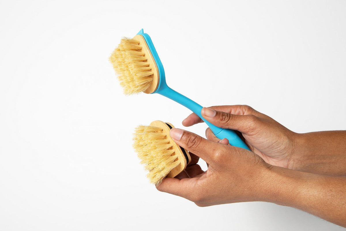 Two hand-held dish brush heads with tan centers and light yellow bristles