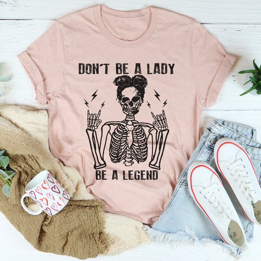 Blush graphic T-shirt with centered skull and “DON’T BE A LADY, BE A LEGEND”
