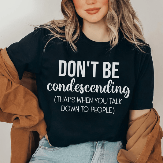 Black crewneck T-shirt with centered white slogan text 'DON'T BE condescending'