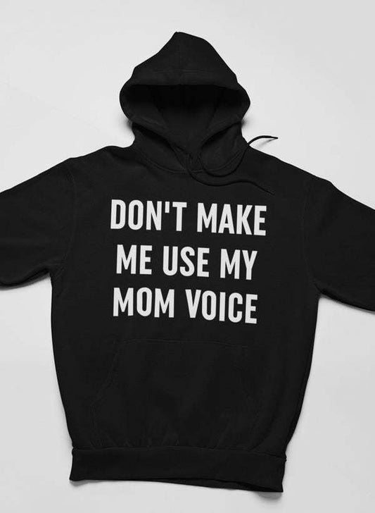 Black hoodie with “DON'T MAKE ME USE MY MOM VOICE” front graphic.