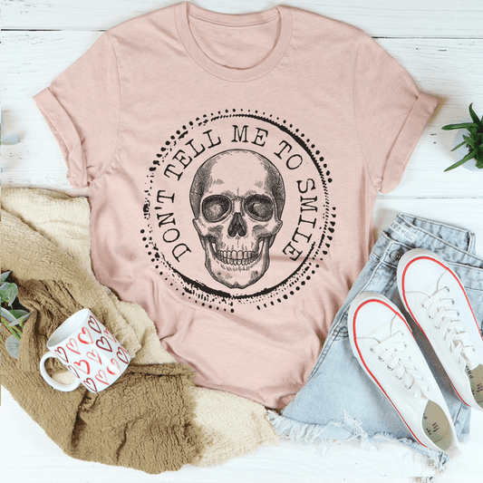 Peach T-shirt, crew neck, with round skull graphic and circular text.