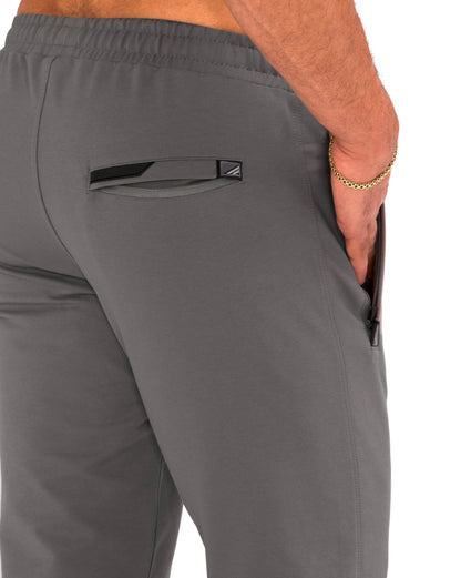Gray athletic sweatpants with elastic waistband, side pocket, and logo patch detail