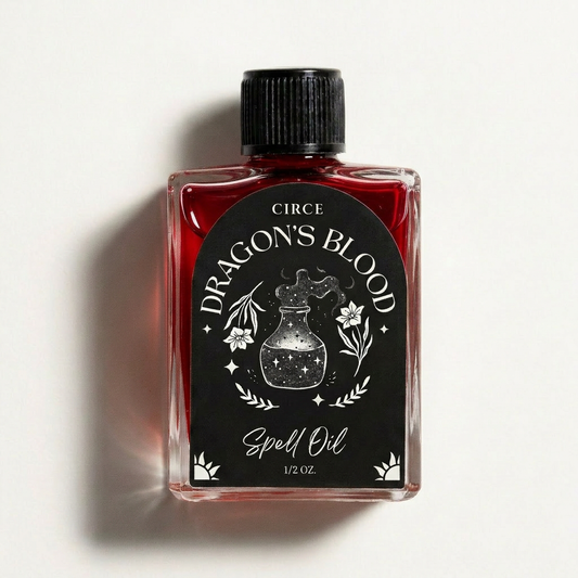 Ritual oil bottle with black cap and red liquid in clear glass; Dragon's Blood label