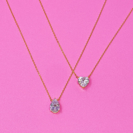 Gold solitaire pendant necklace with heart-shaped clear gemstone charm on a thin chain