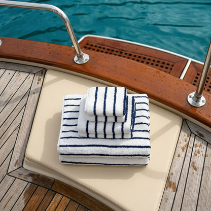 Blue-and-white striped cotton towels, folded on a boat seat