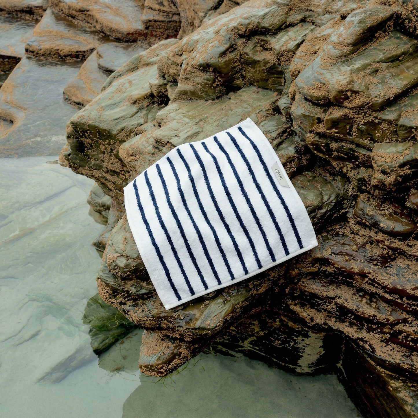 Striped cotton washcloth, white with navy vertical stripes folded