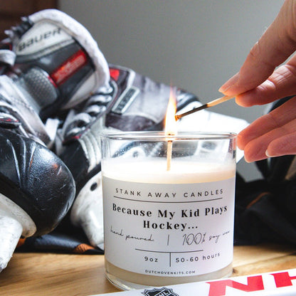 Natural soy wax candle in clear glass jar with white wax; wick lit