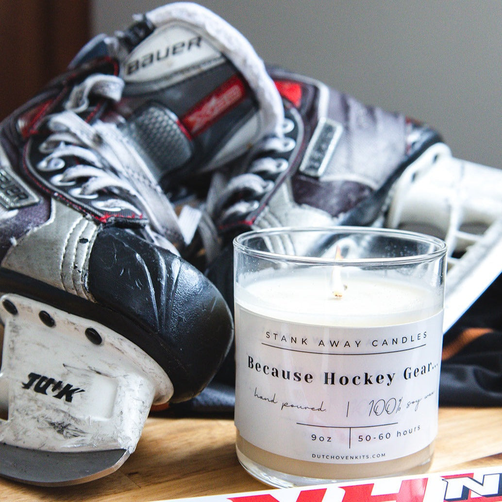 Clear glass soy wax candle with white wax and printed "Because Hockey Gear" label