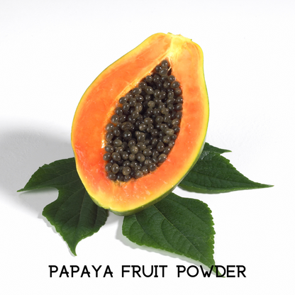 Papaya fruit half with dark seeds and green leaves