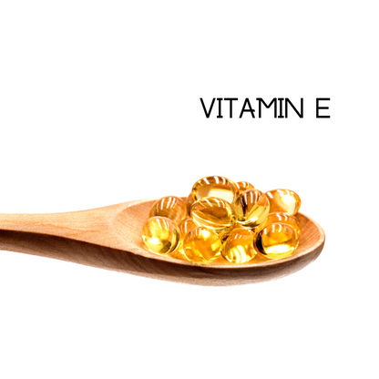 Vitamin E illustration with golden softgels on a wooden spoon and “Vitamin E” text