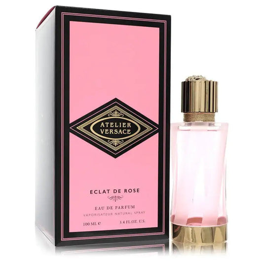 Unisex eau de parfum bottle with gold cap beside pink perfume box