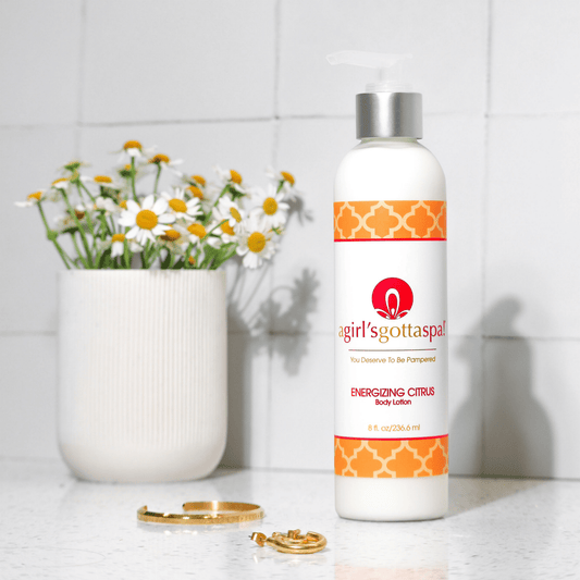 Body lotion bottle with white pump and orange label, with flowers nearby