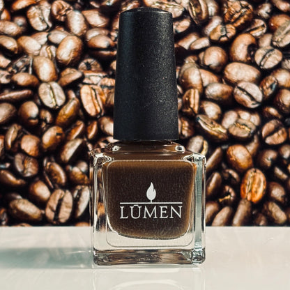 LUMEN nail polish bottle with black cap, espresso-brown liquid.